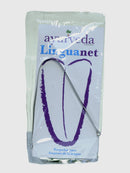 Ein Zungenschaber, verpackt in einem durchsichtigen Plastikbeutel mit einem weiß-blauen Etikett, das "ayurveda autentico Linguanet" liest. Die Verpackung hebt "Raspador para limpieza de la lengua" (Zungenschaber zur Zungenreinigung) hervor und zeigt eine lila Umrissdarstellung einer Zunge.