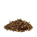 Ein kleiner Haufen getrockneter Kräutertee oder Holzspäne auf weißem Hintergrund.