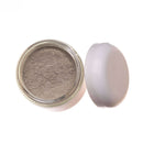 Eine Draufsicht auf ein geöffnetes Glasgefäß mit hellbraunem Pulver, vermutlich der PAAVANI Reiniger und Maske, dessen weißer Deckel daneben auf weißem Hintergrund liegt.