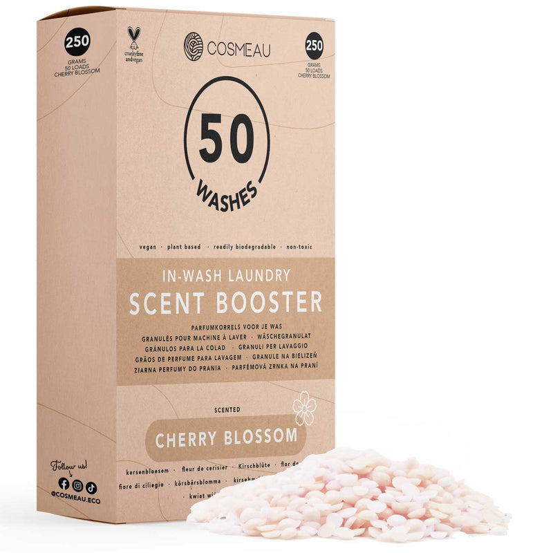 Cosmeau In-Wash Wäscheduft-Booster im Duft "Cherry Blossom", 250 Gramm (50 Wäschen), hebt seine veganen, pflanzlichen, leicht biologisch abbaubaren und ungiftigen Eigenschaften hervor, mit einem Haufen rosa und weißer Duftperlen.