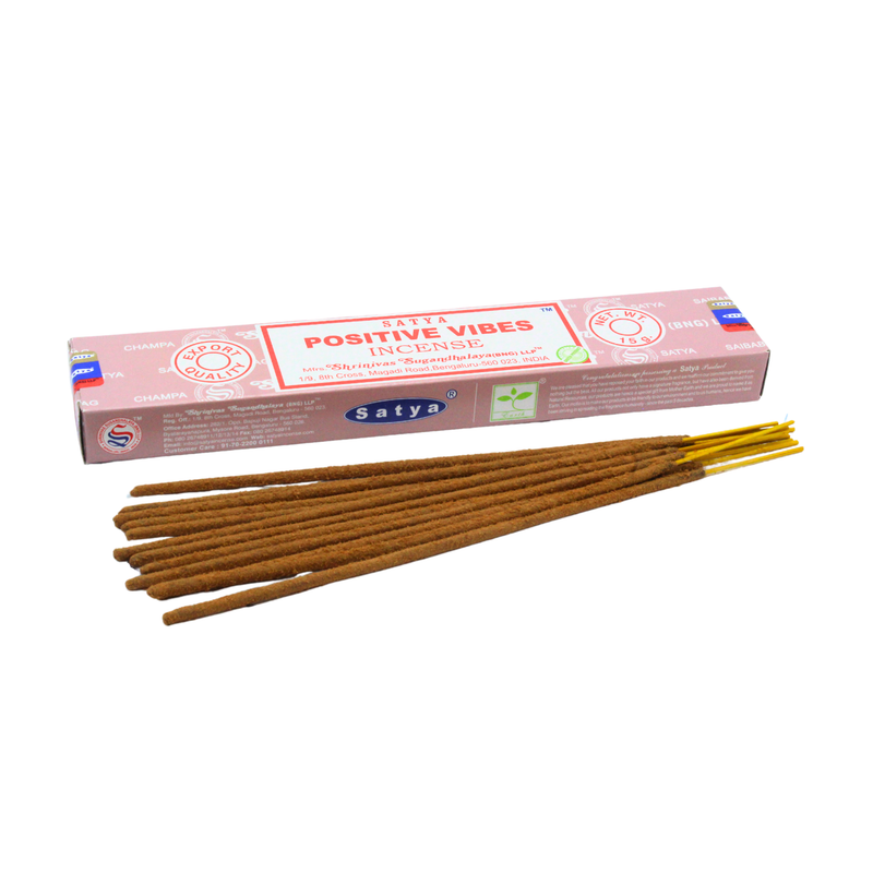 Eine Packung SATYA „Positive Vibes“ Räucherstäbchen, hergestellt von Shrinivas Sugandhalaya, mit einem Bündel brauner Räucherstäbchen davor.