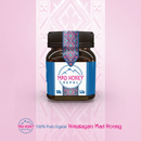 Ein 150-g-Glas mit 100 % reinem biologischem Himalayan Mad Honey aus Nepal vor einem rosa gemusterten Hintergrund.