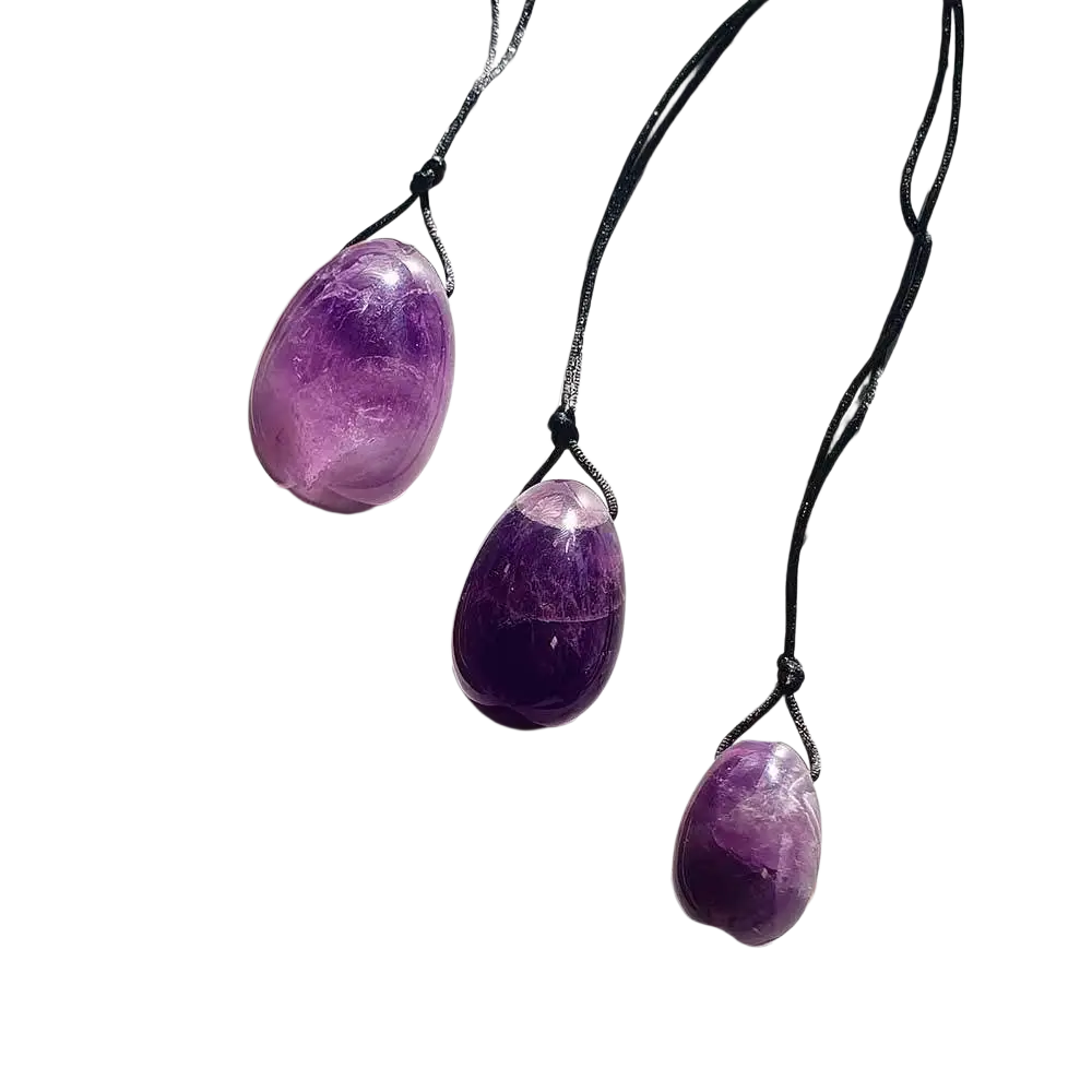 Drei violette Amethyst-Yoni-Eier aus Schmuck mit Loch und Schnur, handgefertigt, als spiritueller Schmuck und Accessoire.