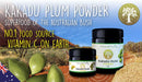 Gläser mit Kakadu-Pflaumenpulver, präsentiert mit frischen Pflaumen und einer australischen Outback-Landschaft.