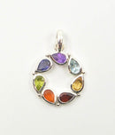 Runder Silberanhänger, gebildet aus sieben tropfenförmigen, facettierten Chakra-Steinen in Regenbogenfarben.