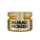 Ein goldener glasbehälter mit anuk manuka-honig mgo250 in hochwertiger premium-honig qualität mit schwarzer beschriftung
