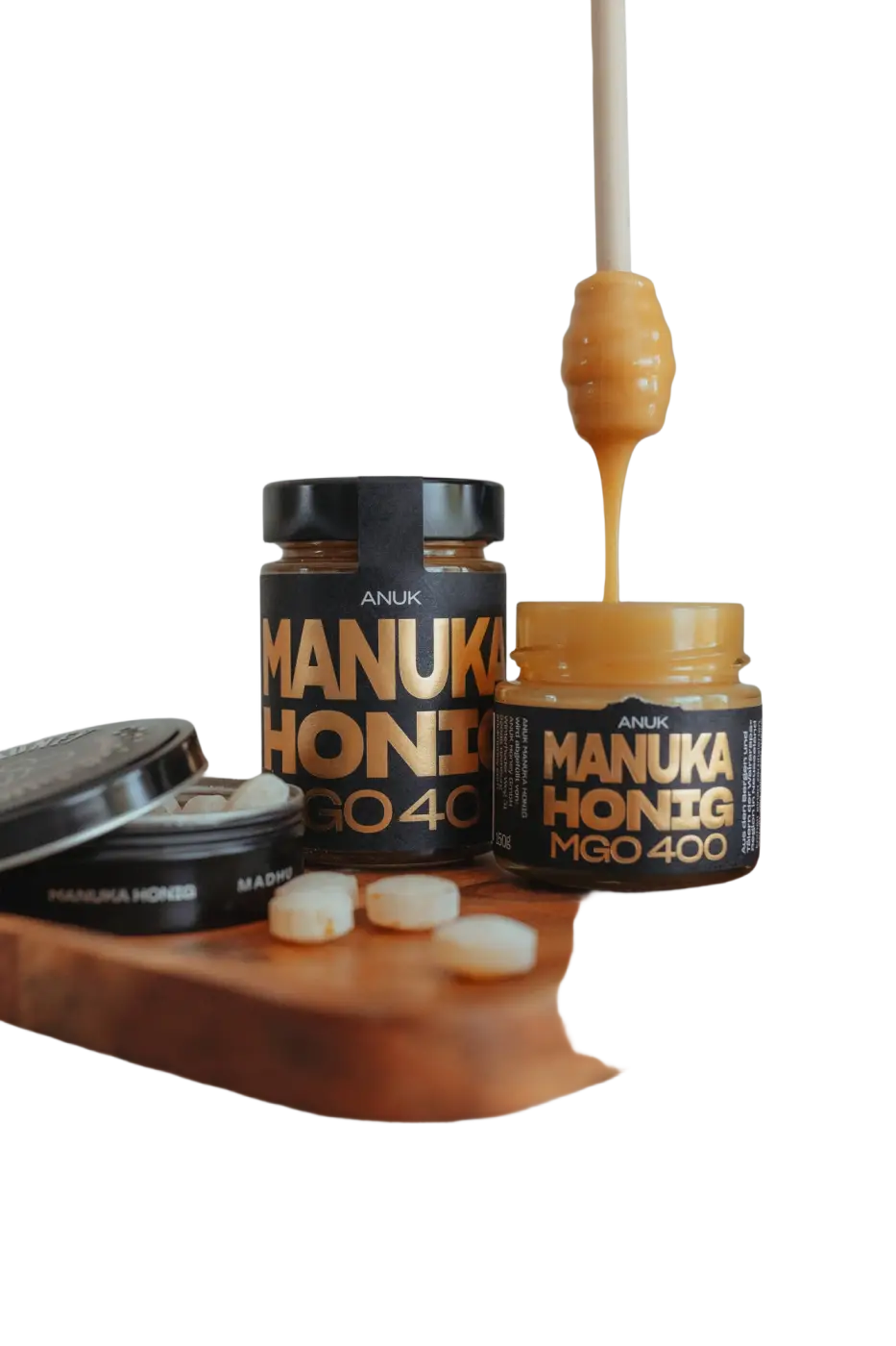 Goldener Honig-Tropfen in einer Holzschale, ANUK Manuka-Honig MGO400+ in Premiumqualität, flüssig und aromatisch.