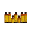Set von sieben bernsteinfarbenen glasflaschen mit schwarzen verschlüssen und gelben etiketten mit apeiron organic sesame ölen aus dem mana shop bern