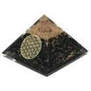 Eine Pyramide aus schwarzen und goldenen Steinen mit einem goldenen, geometrischen Muster.