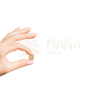Eine hand hält eine kleine runde goldbraune ashwagandha vegane tablette für calm and vitality von mana shop
