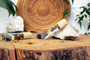 Ätherisches Öl für das dritte Auge mit Ajna Chakra, Kristallen und Kräutern, von Ayamani Naturals, in einer Flasche auf einem Holztablett