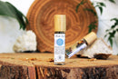 Ätherisches Öl für das dritte Auge mit Ajna Chakra, Kristallen und Kräutern von Ayamani Naturals auf dunklem Hintergrund.