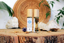 Ätherisches Öl für das dritte Auge mit Ajna Chakra, Kristallen und Kräutern, von Ayamani Naturals, Flasche auf natürlichem Hintergrund
