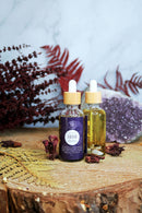 Ätherisches Lilith Öl von Ayamani Naturals mit Mondstein- und Tigeraugenkristallen für feminines Ritual, Flasche mit Kristallen.
