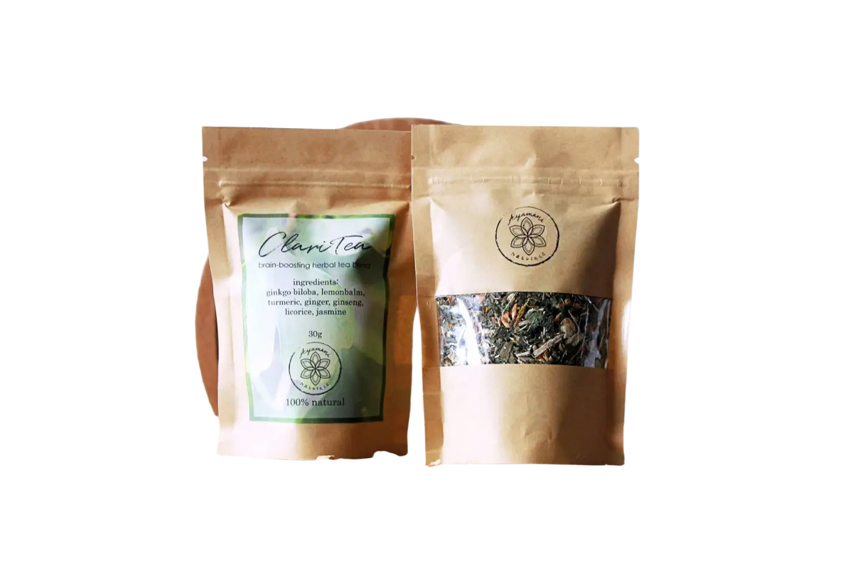 Ayamani Naturals Claritea Zirbeldrüse Entkalkender Kräutertee in einer Teetasse, frische Kräuter und Teeblätter sichtbar