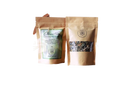 Zwei braune kraftpapiertüten claritea von ayamani naturals mit grünem etikett und sichtfenster decalcifying herbal tea