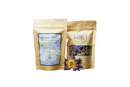 Zwei beige wiederverschließbare ayamani naturals dream well kräutertee-pouches mit klarer fensteransicht getrockneter blumen für luzides träumen und astralprojektion