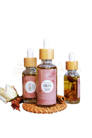 Eine klare glasflasche mit bambustropfer und pinkem etikett, ayamani naturals freya oil für bewusste rituale enthält goldenes öl