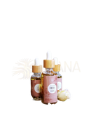 Drei bernsteinfarbene ayamani naturals freya öl tropfflaschen mit bambusverschluss und rosa etiketten für bewusste rituale auf holzstumpf
