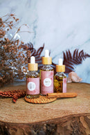 Ayamani Naturals FREYA Öl, feminines Massageöl mit Ritual- und Körperpflege, in einer eleganten Flasche auf natürlichem Hintergrund
