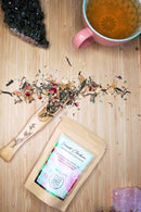 Ayamani Naturals Herzchakra Grüntee mit Jasmin, Rose und Kräutern, frischer Tee in einer Tasse mit Kräutern auf weißem Hintergrund