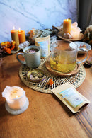 Ayamani Naturals Manifest Tee mit Kräutermischung zur Aktivierung von Manifestation und Inspiration, in einer Tasse mit Kräutern.