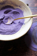 Ayamani Naturals Blauer Samt Latte mit Schmetterlingserbsen, cremiger Tee in blauer Farbe, sichtbarer Teetasse und Mischungsbestandteile