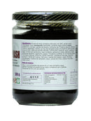 Chyawanprash Ayurveda Auténtico, klassisches Kräuterelixier, in einem Glasbehälter, zeigt die dunkle, klebrige Konsistenz des Lebensmittels