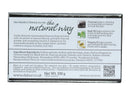 Die Rückseite einer schwarz-weißen Verpackung für "Vatika Naturals Charcoal Soap". Der Text beschreibt die Seife als verjüngend, angereichert mit Basilikumöl, Kohlepulver und Vitamin E, und enthält Inhaltsstoffe sowie Lagerungshinweise.