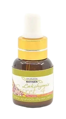 Ein kleines bernsteinfarbenes glasfläschchen mit goldfarbiger pipettenkappe und floralem etikett ayurveda rhynner lakshymis secret 4 care oil zur pflege der nasenschleimhaut