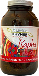 A braunes glas mit silberdeckel und getrocknetem kapha chai bio tee von ayurveda rhyner kapha 100g