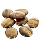 Ein kleiner Haufen glatter, polierter ovaler Tigerauge-Steine mit ihren charakteristischen gold- und braun gestreiften Mustern.