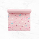 Eine Draufsicht auf eine hellrosa Yogamatte, die auf einer weißen Fläche ausgerollt ist und ein buntes Muster im Terrazzo-Stil mit blauen, weinroten und weißen Akzenten zeigt.