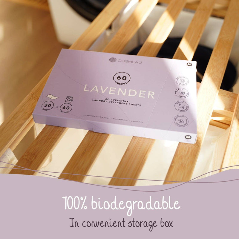 Eine Packung Cosmeau "Lavendel" Umweltfreundliche Waschmittelblätter auf einem Wäschekorb aus Holz, betont die 100% biologisch abbaubare Zusammensetzung und die praktische Aufbewahrungsbox.