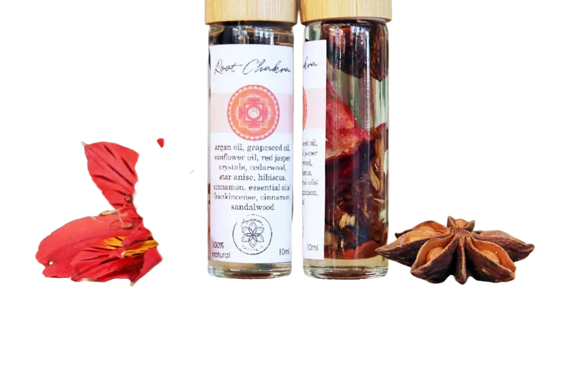 Ätherisches Wurzel-Chakra-Öl von Ayamani Naturals mit Kräutern und Kristallen zur Energieausgleichung, in einer Flasche auf natürlichem Hintergrund.