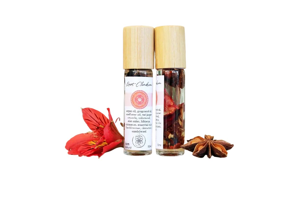 Ätherisches Wurzel-Chakra-Öl mit Kräutern und Kristallen von Ayamani Naturals, zeigt Flasche mit natürlichen Inhaltsstoffen.