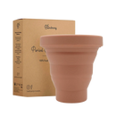 Ein terrakottafarbener, zusammenklappbarer silikon period cup von bamboozzy im period cup sterilisator zur reinigung