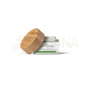 A natural wood lid with engraved branding sits on a white jar of bio gesichtsbalsam moringa-sheabutter from mana shop for intensive care