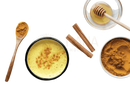 Bio goldene milch latte 100g mit 7 ayurvedischen zutaten in schwarzem keramikbecher mit goldener kurkumamilch und zimt topping für digestion bei mana shop