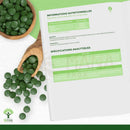 Grüne, runde spirulina und chlorella mix tabletten in einer holzschale mit organische spirulina und chlorella mix tabletten