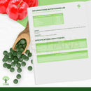 Bio spirulina und vitamin c tabletten aus organischer spirulina und acerola in einem holzlöffel für mehr energie und wohlbefinden