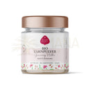 Ein klares glas mit rose gold deckel und weißem etiket bio zahnpulver ginseng für natürliche zahnpflege mit pflanzlicher kraft