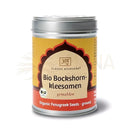 Ein zylindrischer metallbehälter mit silbernem deckel und gelbem etikett für bockshornkleesamen gemahlen bio aus der ayurvedischen küche