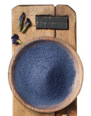 Intensiv blaues Butterfly Pea Pulver aus Clitoria ternatea in einer Holzschale