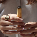 Hände halten einen rauchenden Palo-Santo-Stick zum Räuchern.