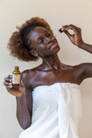 Fünf bernsteinfarbene Glasflaschen mit PAAVANI Ayurveda-Ölen in verschiedenen Größen, darunter eine mit Pumpspender, sind auf einem weißen Hintergrund aufgereiht.