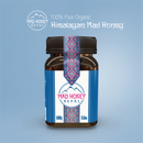 Ein 500g Glas 100% reiner Bio-Himalaya Mad Honey auf einem hellblauen Hintergrund.