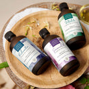 Natürliches Massageöl von Comptoir des Hules, 100% Bio, für entspannende Massagen, flüssige Textur, in einer geöffneten Flasche.