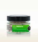 Ein klares Glas mit schwarzem Deckel, gefüllt mit Cosmoveda Bio-Trikatu-Kapseln, einer ayurvedischen Mischung. Das grüne Etikett trägt die Aufschrift "BIO TRIKATU Kapseln" und nennt die Inhaltsstoffe: eine Mischung aus Ingwer, Pippali und schwarzem Pfeffer.