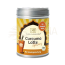 Ein zylindrisches silbernes blech mit gelb-orange etikett der classic ayurveda marke für curcuma latte bio gewürzmischung
